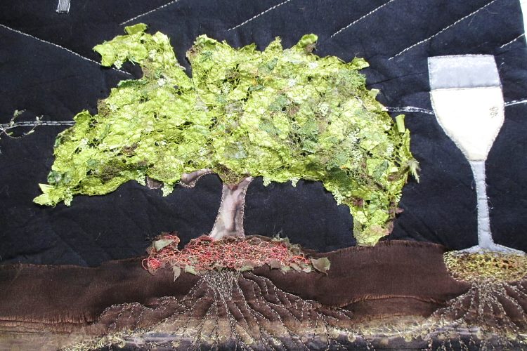 A textured textile art piece depicting a vibrant green tree with bushy leaves and deep roots
